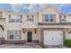 Charming two-story townhouse featuring stone accents, a one-car garage, and inviting front entrance at 4217 High Park Ln, Atlanta, GA 30344