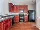 Functional kitchen features dark appliances, wood cabinets, and hardwood floors at 4217 High Park Ln, Atlanta, GA 30344
