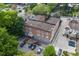 Aerial view of a brick multi-Gathering apartment building with a parking lot surrounded by mature trees at 1026 Saint Charles Ne Ave # 15, Atlanta, GA 30306