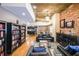 Open living room with a brick wall, hardwood floors, a bookshelf, and a leather sofa at 1026 Saint Charles Ne Ave # 15, Atlanta, GA 30306