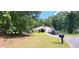 Ranch-style home boasts a well-manicured lawn, mature trees, and a circular driveway providing ample parking at 200 Fox Hall Court Ct, South Fulton, GA 30349