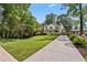 Charming two-story white home with a long concrete driveway, lush green lawn, and mature trees at 2505 Midway Rd, Decatur, GA 30030