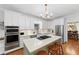Modern kitchen with stainless steel appliances, white cabinets, an island, and hardwood floors at 4250 Green Ridge Dr, Marietta, GA 30062