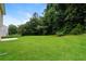 Spacious backyard with lush green lawn and mature trees provides a serene outdoor space at 6481 Alford Way, Lithonia, GA 30058