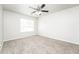 Neutral bedroom showcasing a ceiling fan, window, plush carpet, and ample natural light at 6481 Alford Way, Lithonia, GA 30058