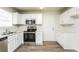 Bright kitchen featuring white cabinets, stainless steel appliances, and wood-look flooring at 6481 Alford Way, Lithonia, GA 30058
