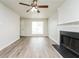 Bright living room featuring a ceiling fan, a large window, a fireplace, and modern floors at 6481 Alford Way, Lithonia, GA 30058
