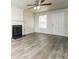Bright living room featuring a ceiling fan, a large window, a fireplace, and modern floors at 6481 Alford Way, Lithonia, GA 30058