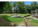 Home's sprawling backyard features a cozy fire pit area, lush landscaping, and mature trees at 7110 Northgreen Dr, Atlanta, GA 30328