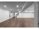 Spacious basement featuring wood floors, access to the backyard, and a staircase to the upper floors at 7110 Northgreen Dr, Atlanta, GA 30328
