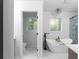 Bright bathroom featuring a freestanding tub, a glass shower, and a stylish chandelier at 7110 Northgreen Dr, Atlanta, GA 30328