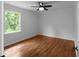 Bright bedroom with hardwood floors, ceiling fan, and a window showcasing the outdoor greenery at 7110 Northgreen Dr, Atlanta, GA 30328