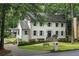 View of the beautiful two-story home with a well-manicured lawn, complemented by mature trees and lush greenery at 7110 Northgreen Dr, Atlanta, GA 30328