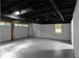 Unfinished basement garage features exposed ceiling, two garage doors, and convenient access to the backyard at 7110 Northgreen Dr, Atlanta, GA 30328