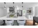 Bright and airy kitchen with white cabinetry, a dark island, stainless steel appliances, and modern lighting fixtures at 7110 Northgreen Dr, Atlanta, GA 30328
