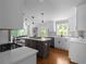 Modern kitchen with white cabinetry, a contrasting dark island, stainless steel appliances, and hardwood flooring at 7110 Northgreen Dr, Atlanta, GA 30328