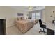 Bright bedroom featuring neutral walls, carpet, two beds, ceiling fan, and an office desk at 2336 Heritage Park Nw Cir # 11, Kennesaw, GA 30144