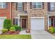 Welcoming front entrance with a decorative wreath, a one-car garage, and pretty landscaping at 2336 Heritage Park Nw Cir # 11, Kennesaw, GA 30144