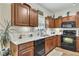 Traditional kitchen with wood cabinets, marble countertops, and black appliances provides a welcoming space at 2336 Heritage Park Nw Cir # 11, Kennesaw, GA 30144