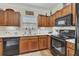 Galley kitchen featuring wood cabinetry, granite countertops, and modern appliances at 2336 Heritage Park Nw Cir # 11, Kennesaw, GA 30144