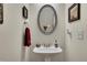 Stylish powder room featuring a pedestal sink, oval mirror, and decorative accents at 2336 Heritage Park Nw Cir # 11, Kennesaw, GA 30144