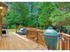 Back deck with grill and seating area overlooks wooded backyard at 130 Silver Mist Cir, Alpharetta, GA 30022