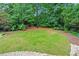 Lush green backyard with mature trees, providing a private and serene outdoor space at 130 Silver Mist Cir, Alpharetta, GA 30022