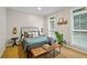 Well-lit bedroom with queen bed, plantation shutters, and decorative wall accents at 130 Silver Mist Cir, Alpharetta, GA 30022