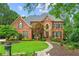 Charming two-story brick home featuring manicured lawn and mature landscaping at 130 Silver Mist Cir, Alpharetta, GA 30022