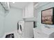 Well-equipped laundry room featuring a sink, cabinetry, and modern washer and dryer at 130 Silver Mist Cir, Alpharetta, GA 30022