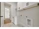 Modern laundry room with marble floors, white cabinets, and black hardware at 133 Daxton Dr, Canton, GA 30115