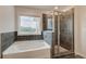 Bathroom with gray tiled shower and tub with large window to exterior at 247 Arnewood Cir, Mcdonough, GA 30253