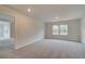 Large bedroom with neutral carpet, two windows offering natural light, and an adjacent room at 247 Arnewood Cir, Mcdonough, GA 30253