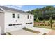 Rear view of new townhomes with white siding, two-car garages, and green space at 372 Sound Cir, Stockbridge, GA 30281
