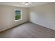 Neutral bedroom with wall-to-wall carpeting, large window overlooking a landscaped backyard at 3695 Santa Rosa Way, Douglasville, GA 30135