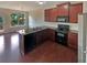 Open kitchen with dark cabinets, granite countertops, stainless steel appliances, and hardwood floors at 3695 Santa Rosa Way, Douglasville, GA 30135