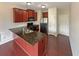 Compact kitchen featuring dark wood cabinets, granite countertops, and stainless steel appliances at 3695 Santa Rosa Way, Douglasville, GA 30135
