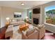 Cozy living room with a fireplace, plush seating, and large windows offering natural light at 3695 Santa Rosa Way, Douglasville, GA 30135