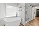 Modern bathroom features a soaking tub beneath a window and a glass enclosed shower at 615 Rosedown Way, Alpharetta, GA 30022