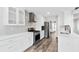 Stylish kitchen with white cabinetry, stainless appliances, stone countertops and wooden floor at 615 Rosedown Way, Alpharetta, GA 30022