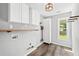 Functional laundry room with overhead cabinets, shelving, and natural light from the window at 615 Rosedown Way, Alpharetta, GA 30022