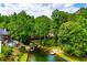 Stunning aerial view of a lakefront home with mature trees, private dock, boat house, gazebo, and sandy beach area at 9018 Lakeview Pkwy, Villa Rica, GA 30180