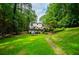 Expansive backyard with a lush lawn, stone accents, and mature trees at 9018 Lakeview Pkwy, Villa Rica, GA 30180