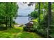 Beautifully landscaped backyard with mature trees, leading to a private gazebo and dock on the lake at 9018 Lakeview Pkwy, Villa Rica, GA 30180