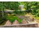 View of a home nestled in a heavily treed area with a driveway winding down to the property at 9018 Lakeview Pkwy, Villa Rica, GA 30180