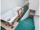 Hallway featuring a jetted tub next to a staircase with green carpet at 9018 Lakeview Pkwy, Villa Rica, GA 30180