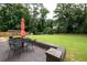 Outdoor patio with a black metal table and chairs overlooking the expansive and well-maintained backyard at 1908 Musket Ct, Stone Mountain, GA 30087