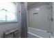 Updated bathroom featuring a tub with shower, window, gray walls, and a vanity unit at 1908 Musket Ct, Stone Mountain, GA 30087