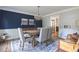 Elegant dining room with a rustic wood table, chandelier, and a stylish blue accent wall at 1908 Musket Ct, Stone Mountain, GA 30087