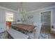 Dining room with a chandelier, rustic wood table, and open access to other living spaces at 1908 Musket Ct, Stone Mountain, GA 30087